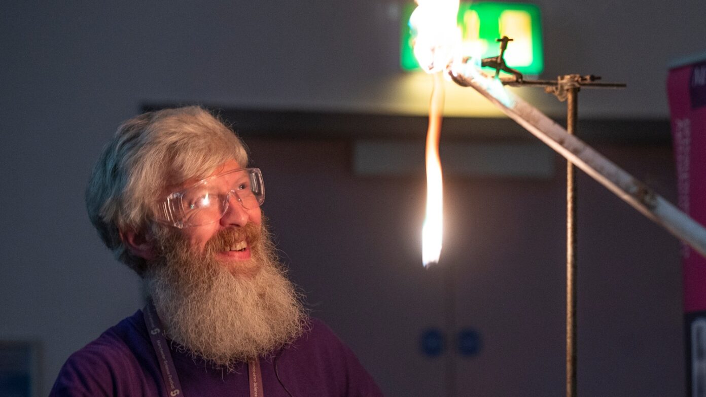 Academic performing a demonstration with fire.
