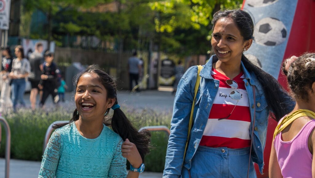 A mother and daughter smiling on campus.