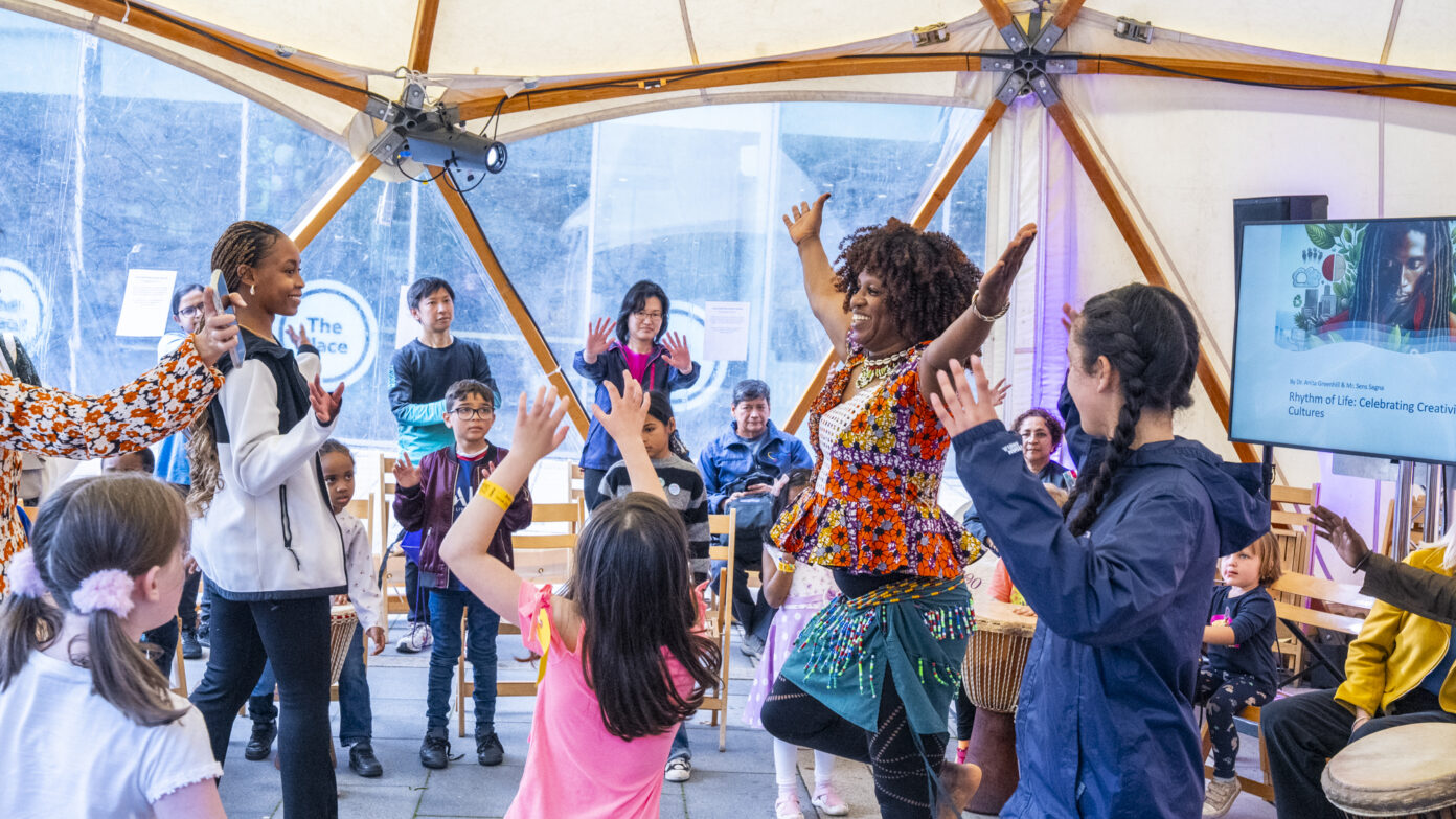 Adults and children are smiling and dancing