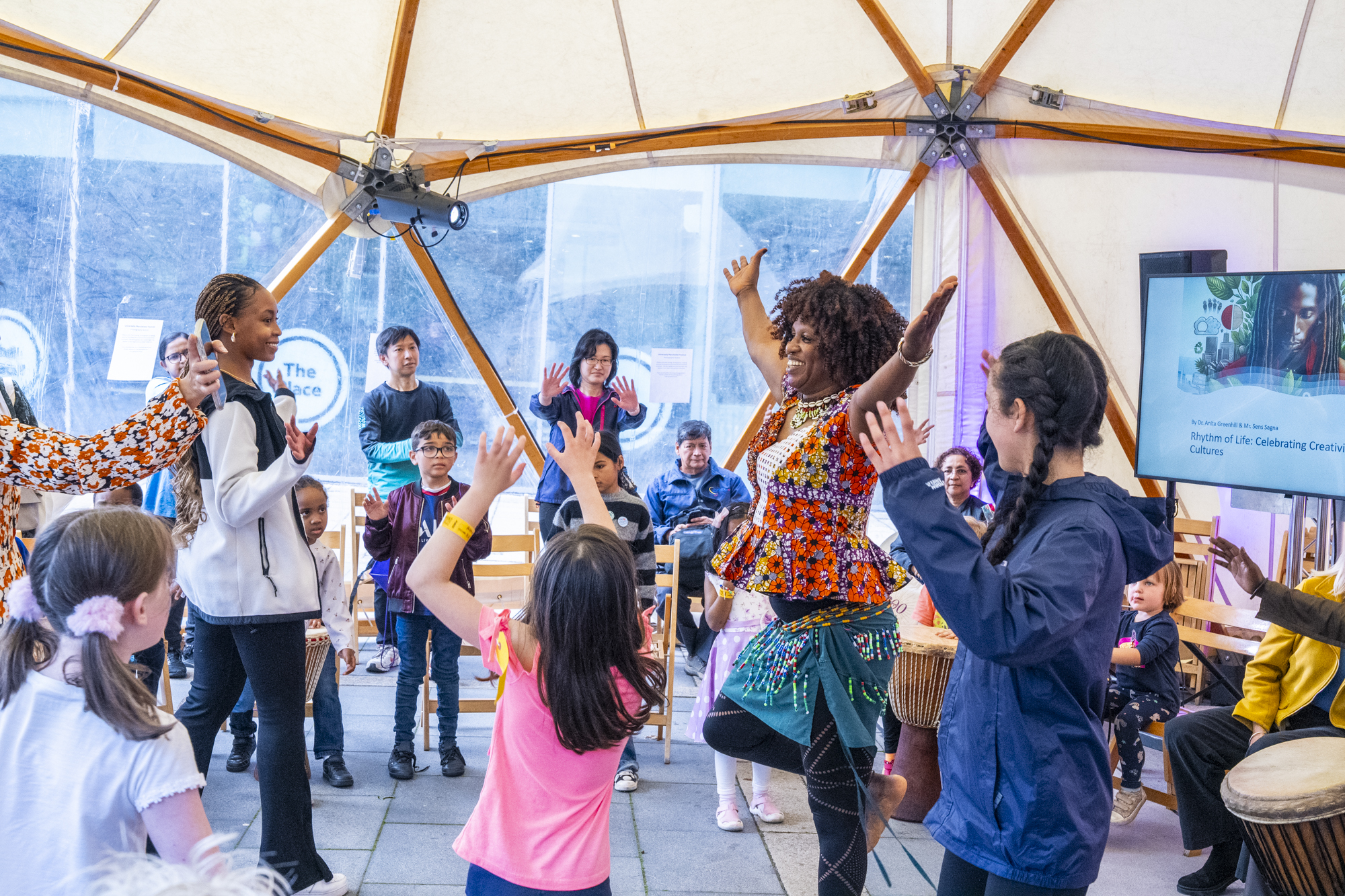 Adults and children are smiling and dancing 